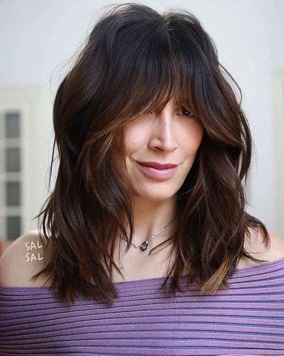 Medium-Length Layered Haircut with Face-Framing Bangs: