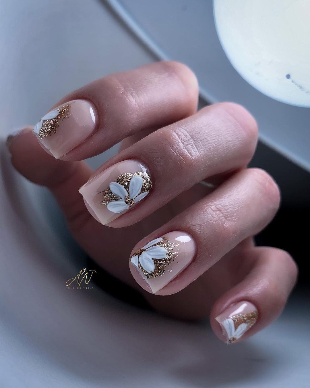 Sheer Pink Nails with White Flowers and Gold Glitter Accents