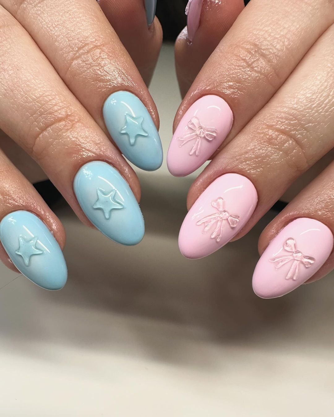 Alternating Pastel Blue and Pink Oval Nails with Embossed Stars and Bows