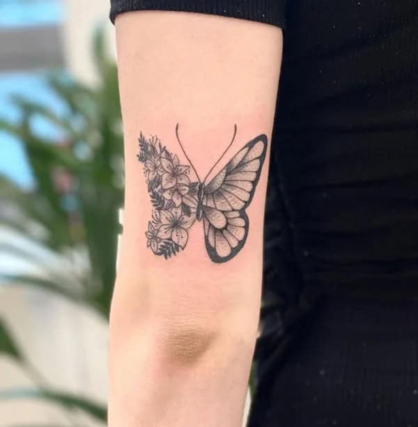 Half butterfly half flower forearm tattoo