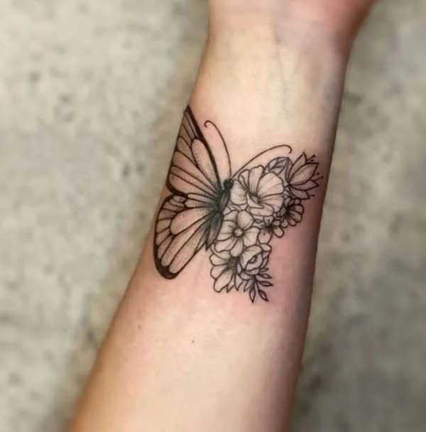 Half butterfly half flower forearm tattoo