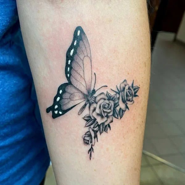 Half butterfly half flower forearm tattoo