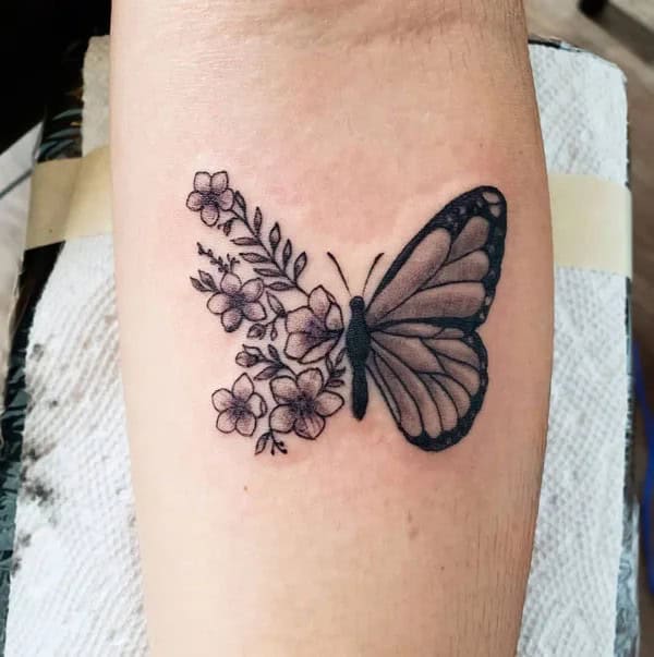 Half butterfly half flower forearm tattoo