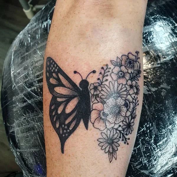 Half butterfly half flower forearm tattoo