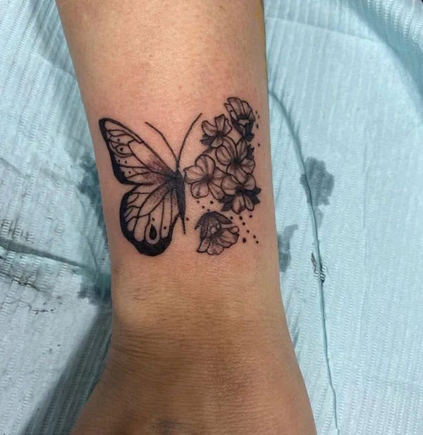 Half butterfly half flower forearm tattoo