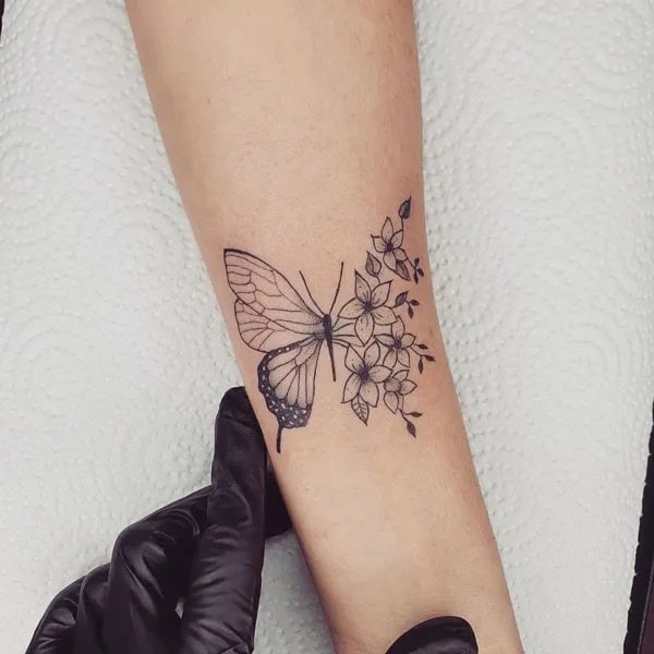 Half butterfly half flower forearm tattoo