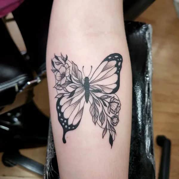 Half butterfly half flower forearm tattoo