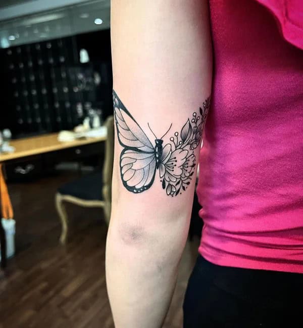 Half butterfly half flower forearm tattoo