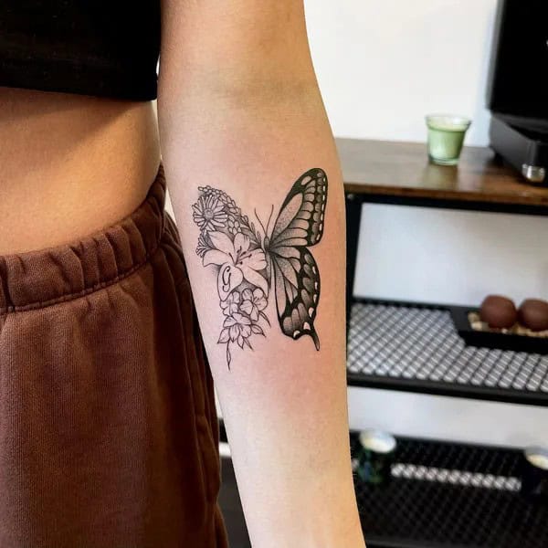 Half butterfly half flower forearm tattoo